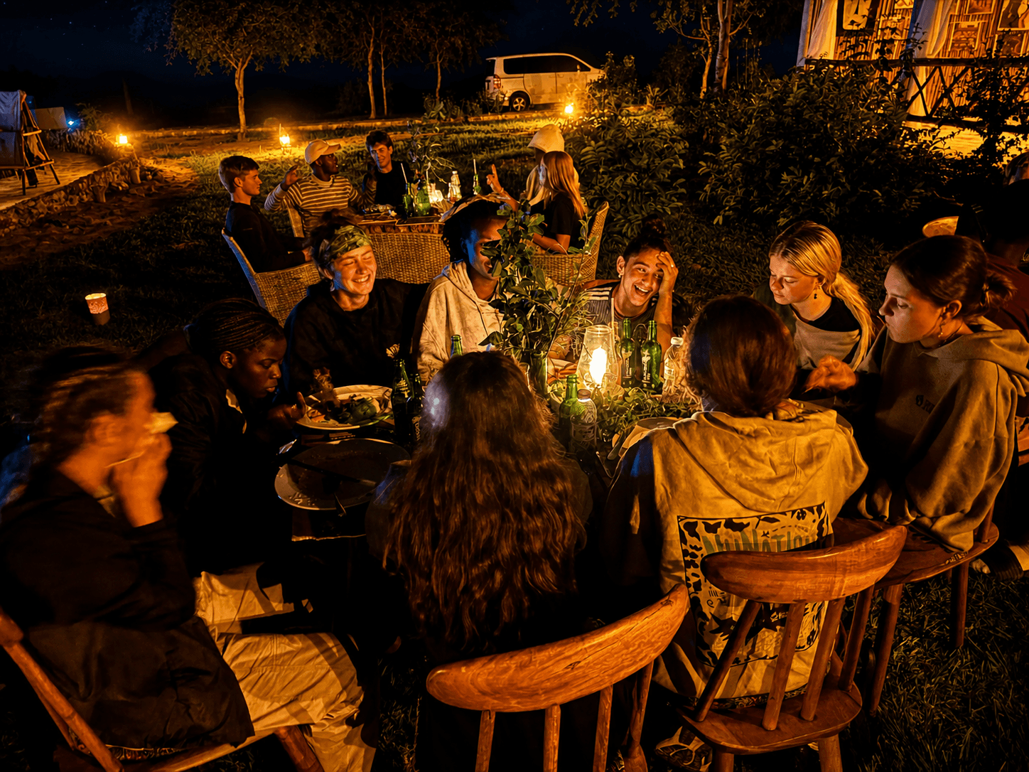 Guests dining outdoors at night around a candlelit table at The Elephant Oasis, Murchison Falls Uganda